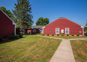 Thumbnail 9 of 19 - a red barn with a sidewalk in front of it
