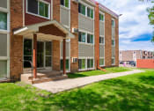 Thumbnail 7 of 28 - a brick building with a porch and a sidewalk in front of it