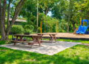 Thumbnail 25 of 28 - a picnic table and a playground in a park