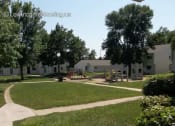 Thumbnail 5 of 6 - a park with a playground and houses in the
