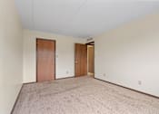 Thumbnail 21 of 29 - a spacious living room with carpet and a door to a hallway