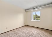 Thumbnail 17 of 29 - an empty living room with a window and carpet