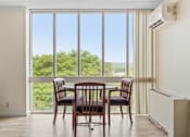 Thumbnail 28 of 29 - a dining room with a table and chairs in front of a window