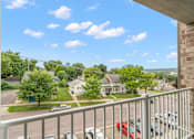 Thumbnail 7 of 29 - the view from the balcony of an apartment building with cars parked in a parking lot