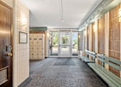 Thumbnail 9 of 29 - a hallway with benches and mailboxes and doors in a building