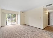 Thumbnail 15 of 29 - an empty living room with a sliding glass door to a patio