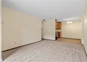 Thumbnail 14 of 29 - the living room and kitchen of an empty house with white walls and carpet