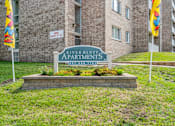 Thumbnail 2 of 29 - the sign for riverbank apartments in front of a brick building