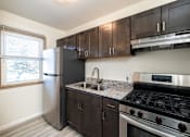 Thumbnail 1 of 10 - A kitchen with a stainless steel refrigerator, sink, and stove.