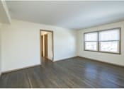 Thumbnail 10 of 10 - A room with a wooden floor and a window with blinds.