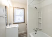 Thumbnail 9 of 10 - A white bathroom with a tub and sink.