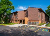 Thumbnail 3 of 18 - a large brick building with a parking lot in front of it