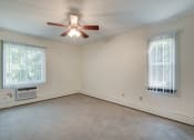 Thumbnail 8 of 13 - an empty living room with a ceiling fan and two windows