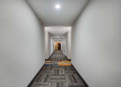 Thumbnail 12 of 13 - a long corridor with a carpet and white walls and a door