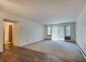 Thumbnail 6 of 13 - the living room and dining room of an apartment with wood flooring and white walls