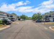 Thumbnail 5 of 6 - an empty street with houses on either side and cars parked