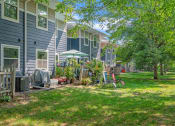 Thumbnail 3 of 6 - a group of blue houses with a lawn and trees in front of them