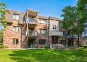 Thumbnail 7 of 19 - a brick apartment building with balconies and a lawn