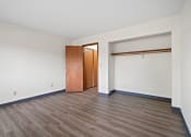 Thumbnail 16 of 20 - an empty living room with wood flooring and a door to a closet