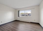 Thumbnail 17 of 20 - the living room of an empty apartment with wood flooring and a window