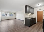 Thumbnail 12 of 20 - an empty kitchen and living room with a refrigerator and a sink