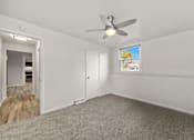 Thumbnail 7 of 10 - A room with a ceiling fan and a window with a view of a garden.