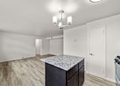 Thumbnail 3 of 10 - A kitchen with a granite countertop and a chandelier.