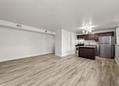 Thumbnail 5 of 10 - A kitchen area with a refrigerator, sink, and cabinets.