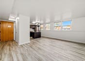 Thumbnail 4 of 10 - A room with a wooden door and a white wall.