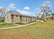 Thumbnail 2 of 7 - A row of houses with a grassy area in front.