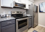 Thumbnail 7 of 80 - A modern kitchen with a stainless steel refrigerator, oven, and microwave.at Addison at Sutherland, Tennessee, 37909