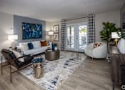 Thumbnail 8 of 80 - A living room with a large painting on the wall and a sofa with a black and white patterned throw pillow.at Addison at Sutherland, Knoxville, TN  