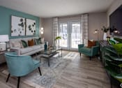 Thumbnail 15 of 80 - A living room with a couch, chair, and potted plant.at Addison at Sutherland, Knoxville, TN 37909  