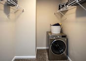 Thumbnail 31 of 80 - A laundry room with a washer and dryer and a basket on top of the dryer.at Addison at Sutherland, Tennessee, 37909