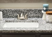 Thumbnail 57 of 80 - A bathroom sink with a marble countertop and a white faucet.at Addison at Sutherland, Knoxville, 37909  