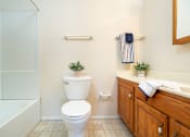 Thumbnail 8 of 16 - A white toilet sits in a bathroom next to a sink.