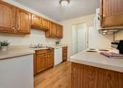 Thumbnail 7 of 16 - A kitchen with wooden cabinets and white appliances.