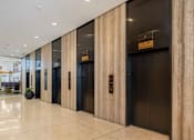 Thumbnail 18 of 34 - a row of elevators in a lobby of a building