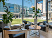 Thumbnail 17 of 34 - a seating area with chairs and a table in front of a building