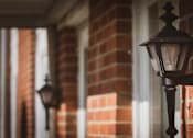 Thumbnail 13 of 16 - A black street lamp is mounted on a brick wall.