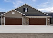 Thumbnail 4 of 23 - A house with two garages and a driveway in front.