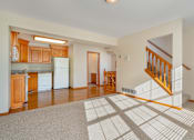 Thumbnail 11 of 14 - A spacious living room with a staircase leading to the upper floor.