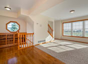 Thumbnail 10 of 14 - A spacious room with a staircase and a large window.