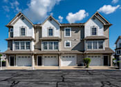 Thumbnail 3 of 14 - A large, two-story house with a garage on the ground floor.