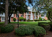 Thumbnail 1 of 10 - A large building with a white front porch and a black lamp post.