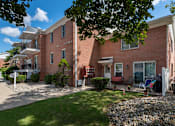 Thumbnail 10 of 10 - A red brick apartment building with a green lawn in front.