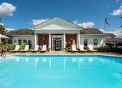 Thumbnail 5 of 20 - A white house with a pool in front.