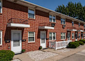 Thumbnail 13 of 16 - A row of red brick houses with white doors and windows.