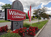Thumbnail 17 of 20 - A sign for Wildwood Commons townhomes is shown in front of a building.