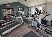 Thumbnail 7 of 20 - A gym with treadmills and elliptical machines.